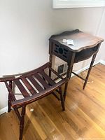 side table and luggage rack together against wall