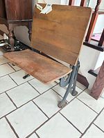 Front view showing wood backrest, seat and iron legs