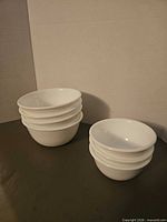 Two stacks of white Corelle bowls showing quantity and size difference