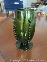 Front view of green blown glass vase with applied trail decoration