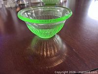 Side profile of uranium glass bowl showing ribbed body, flared rim, green color