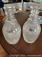 Front view of both cut crystal decanters on table