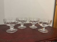 Four cut crystal champagne coupes on wooden surface