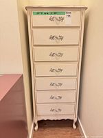 Front view of cream 7-drawer tallboy chest showing entire piece and hardware