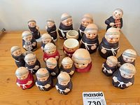 Group view of all 19 ceramic monk pieces on table