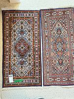 Pair of small Persian style rugs side by side showing full design and colors