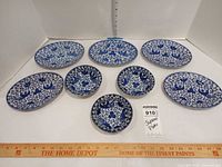 Eight blue and white porcelain pieces laid out with ruler for scale