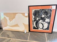 Overall view of both framed prints leaning against wall
