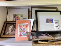 Shelf with multiple framed items stacked