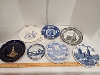 All eight decorative plates arranged with ruler for scale