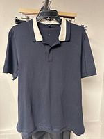 Front view of navy polo with contrast collar