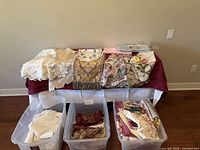 Overall lot displayed on table and in three storage bins
