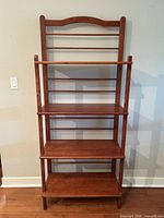 Front view of cherry finish bookshelf showing four shelves and open slat back