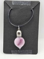 Front view of necklace displaying glass pendant and black cord