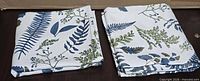 Two folded curtain panels showing overall botanical design