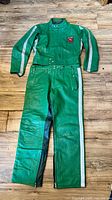 Full view of green Polizei leather jacket and one pants laid out