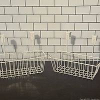 both white metal over-door baskets side by side