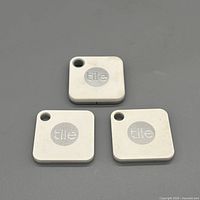 Front view of three Tile Mate trackers showing logos and keyring holes