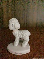 Lamb figurine front view showing textured fleece and base inscription
