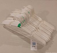 Stack of white plastic clothes hangers bundled together
