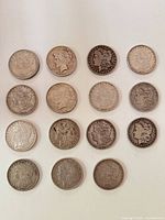 Fifteen silver dollars laid out in five rows