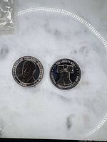 Both coins side by side on light background