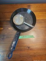 Large enamelware skillet with small tin pan nested inside