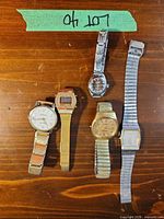 Group shot of all five wristwatches arranged on table
