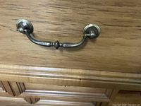 close-up of brass bail pull on dresser drawer