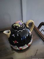 Front angle of teapot showing floral band and handle