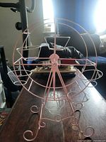 Full view of pink metal cupcake ferris wheel stand on table