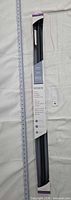 Front of boxed Moen tension shower rod showing length scale