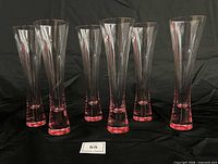 Six Veuve Clicquot flutes upright on black background