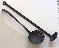 Both iron ladles side by side showing size difference