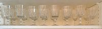Front view of 16 crystal glasses lined in cabinet