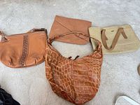 Four handbags laid out on carpet