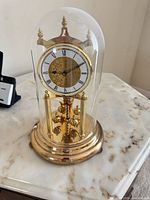 Full view of brass 400-day clock under glass dome