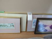 Two framed prints: panoramic geese and figurative seaside scene in gold metal frames