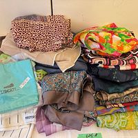 Stack of folded scarves and shawls showing colours and patterns