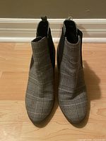 Top view of both boots showing plaid fabric and overall condition