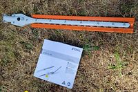 Attachment with orange guard alongside manual