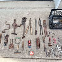 Full group of assorted vintage hand tools laid out on concrete