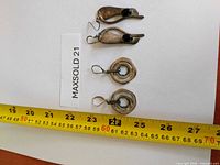 Both earring pairs laid beside tape measure