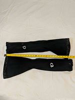 Full view pair of leg warmers with tape measure showing length