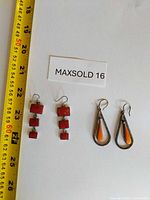 Both earring pairs beside tape measure and lot card