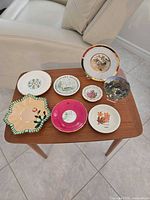 Group shot of all eight souvenir saucers arranged on table