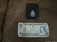 Front of 1973 $1 banknote and closed presentation case