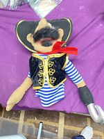 Full view of pirate plush doll with hat, vest, hook hand, and tag