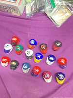 All 17 miniature helmets arranged on surface showing variety of team logos