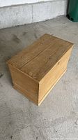 Three-quarter view of the closed solid wood blanket chest